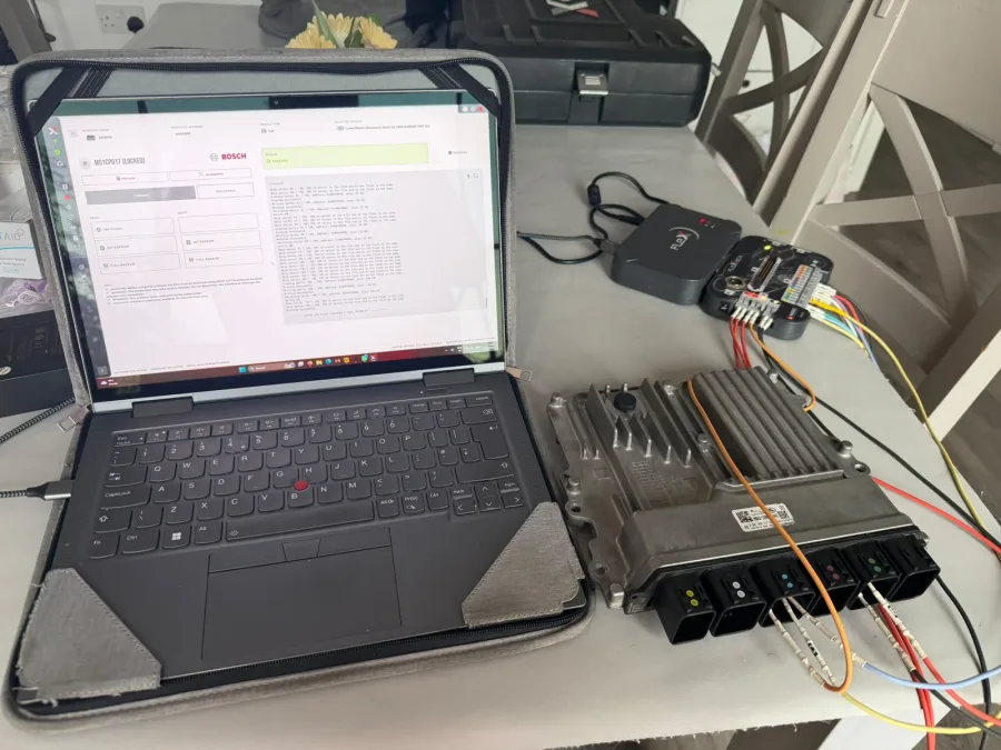 Laptop connected to vehicle electronics on a workbench