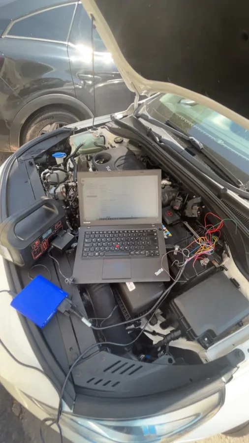 Laptop and cables beside an open engine bay